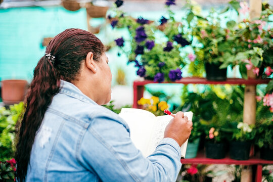 Back view of a nursery worker writing in a notebook