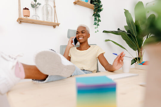 Smiling black woman having phone conversation in office