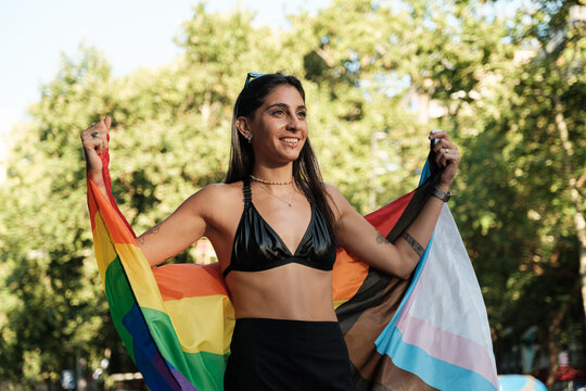 Smiling woman holding rainbow flag