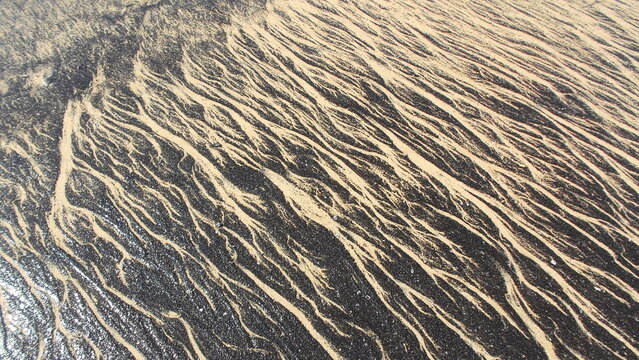 TEXTURA CREADA POR EL ALQUITR&Aacute;N EN LA ARENA DE  LA PLAYA. BREA Y ARENA. CONTAMINACI&Oacute;N.