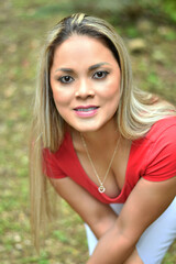 Naklejka premium Retrato de una mujer latina con cabello rubio, sonriente y muy bella, en un ambiente natural.