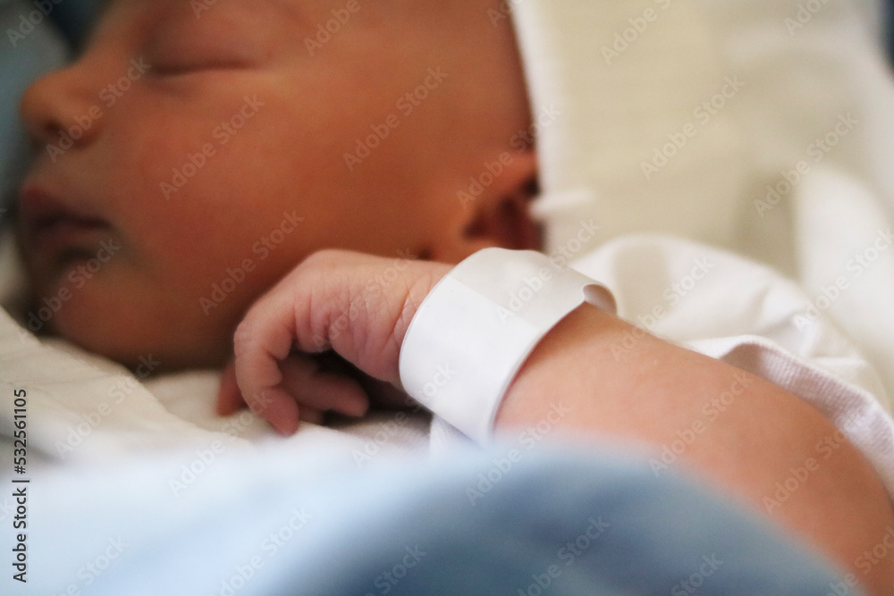 Wall mural Newborn baby at hospital with identity tag 