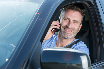 smiling male driver using his telephone
