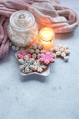 christmas gingerbread cookies, candle, jar with marsmallows and scarf on table. cozy Christmas background. Festive winter season concept. Christmas holiday