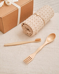 Gift set of natural beige muslin towel wooden spoon-fork and bamboo toothbrush. Reusable eco-friendly home supplies. Zero waste and a safe, plastic-free lifestyle. View from above.