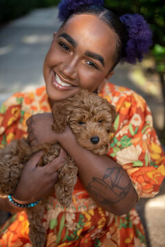 A non binary model posing with their puppy 