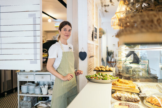 A cafeteria clerk placing a salad on the counter