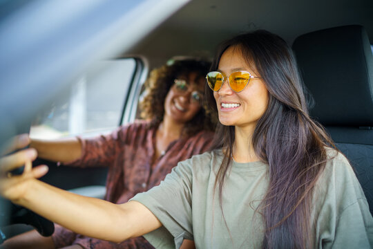 Two women smile for selfie while sitting in car