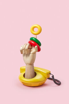 Wooden hand from telephone with plastic rings.