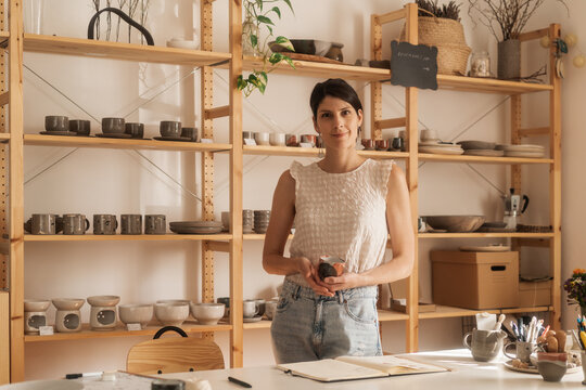 Portrait Of A Female Shop Owner Holding A Ceramic Cup