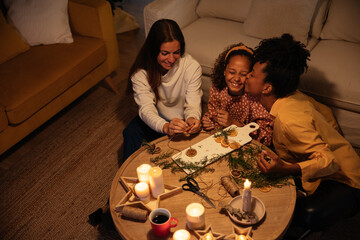 Happy lesbian couple with kid creating Xmas decorations