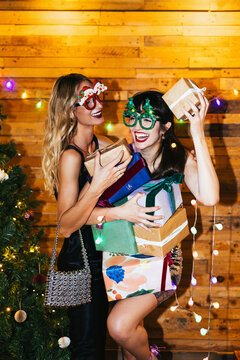 Ladies with gift boxes laughing during Xmas party