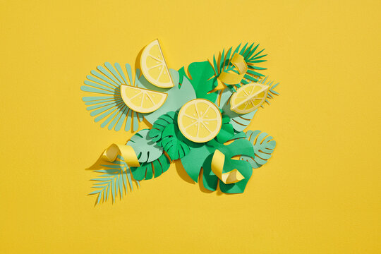 Lemon fruits and slices with leaves cut out of paper