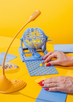 Bingo game with female hands on yellow background.