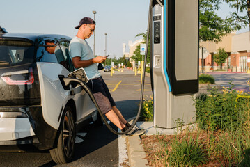 Man waiting for car to charge