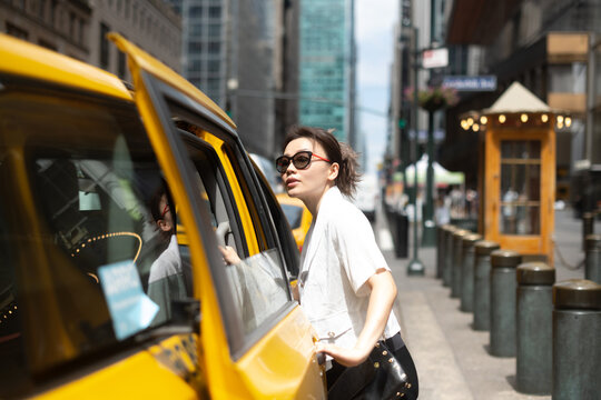 Professional Woman Getting Into Cab In Manhattan