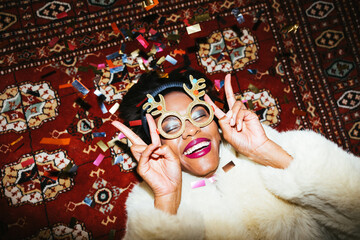 Black woman gesturing V sign on carpet