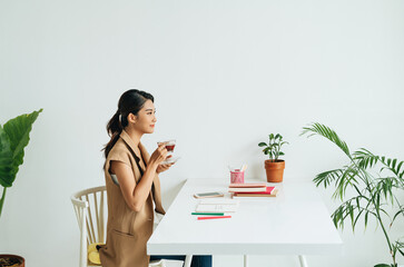 Young asian woman hand holding and drinking coffee while reading