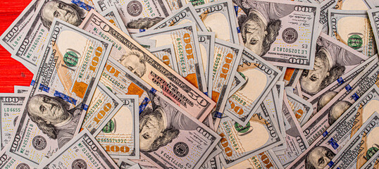 Obraz premium Dollars on a red wooden background. Money on the table. American dollars.