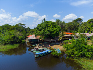 Fototapeta na wymiar Aerial view of a local guest house in the amazon rainforest with a little pier and small wooden shacks