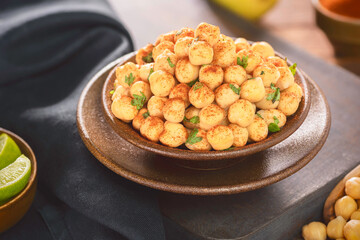 Arabic cuisine; Close up for cooked spiced chickpeas in small bowl. Served with fresh lemon and spices.