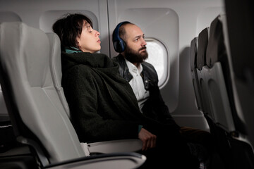 Frightened woman waiting for plane to takeoff and fly abroad, feeling scared about aerial departure on jet. Travelling by airplane on commercial flight to go on holiday vacation trip.