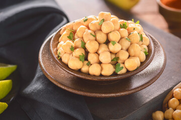 Arabic cuisine; Close up for cooked chickpeas in small bowl. Served with fresh lemon and spices.