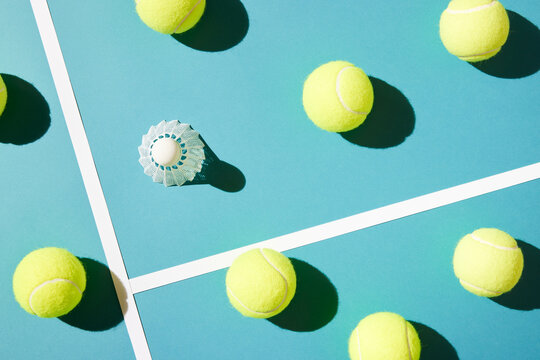 Badminton shuttlecock amidst tennis balls