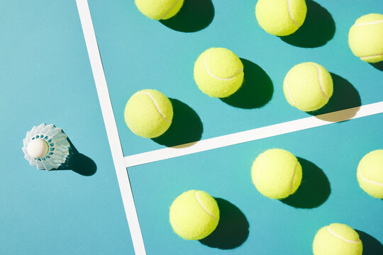 Bunch of tennis balls against badminton shuttlecock