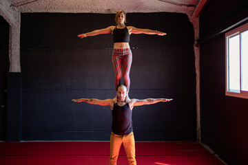 Skilled circus artist standing on partner shoulders