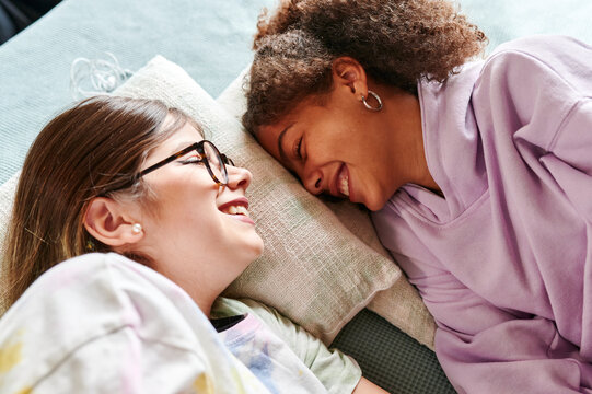 Teen Girls Laughing On A Bed