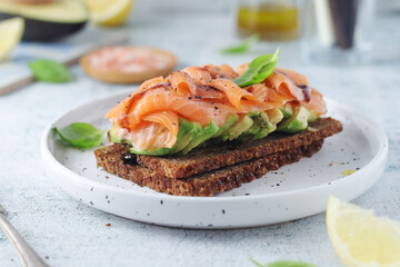 A rye bread sandwich with avocado and salmon