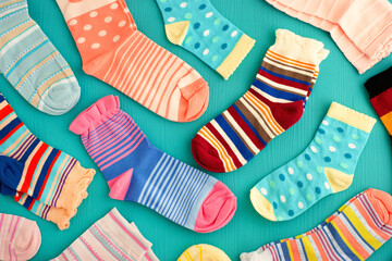 Bright socks on a turquoise background. Jersey clothing in the form of socks. Socks for autumn and winter.