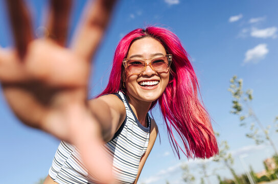 Happy chinese woman with pink hair