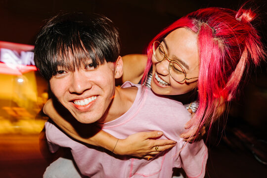 Cheerful Chinese Couple Making Piggyback At Night