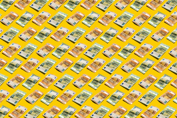 Fifty and hundred euro banknotes pattern on bright yellow background