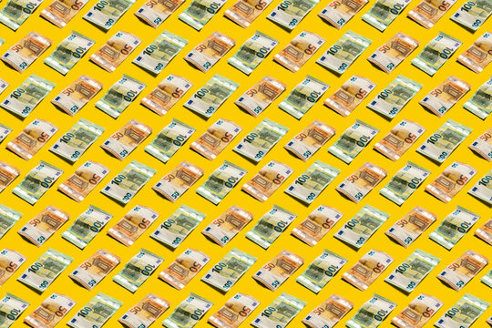 Fifty and hundred euro banknotes pattern on bright yellow background