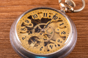antique skeleton style brass pocket watch with patina on a wood background - Powered by Adobe