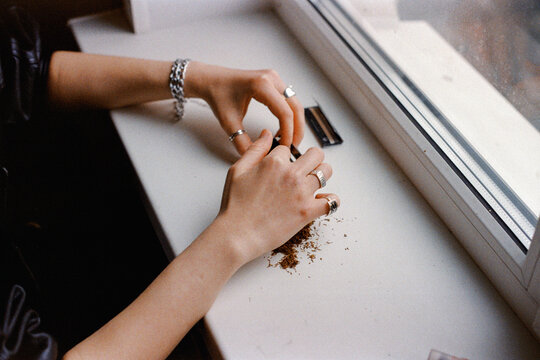 hands of young  woman making cigarette 