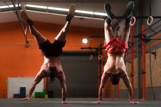 Crossfit athletes doing handstand walk at the gym