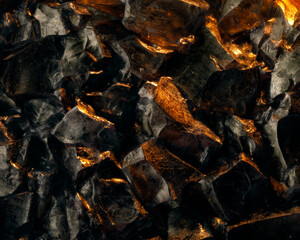 Dark black stones glittering with shiny golden light.