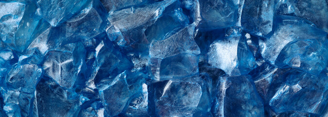 Chunks of clear glittering blue ice. Abstract cold or frozen winter background.