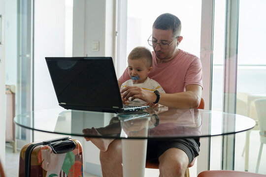  Father working from the hotel with his son