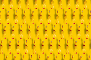 Pattern of screaming chicken toys isolated on a yellow background