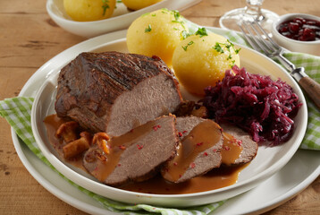 Meat with potato dumplings and sauerkraut on plate