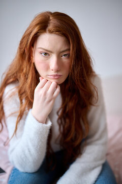 Focused girl leaning chin on hand.