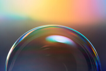 Soap bubble with flicker on iridescent background.
