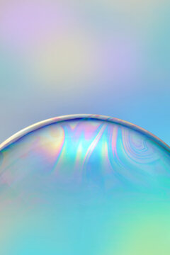 Pearlescent bubble on iridescent background.