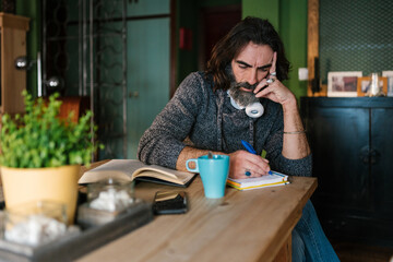 Man writing in notebook at home