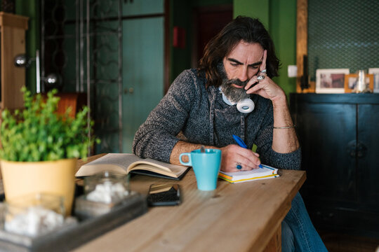 Man writing in notebook at home